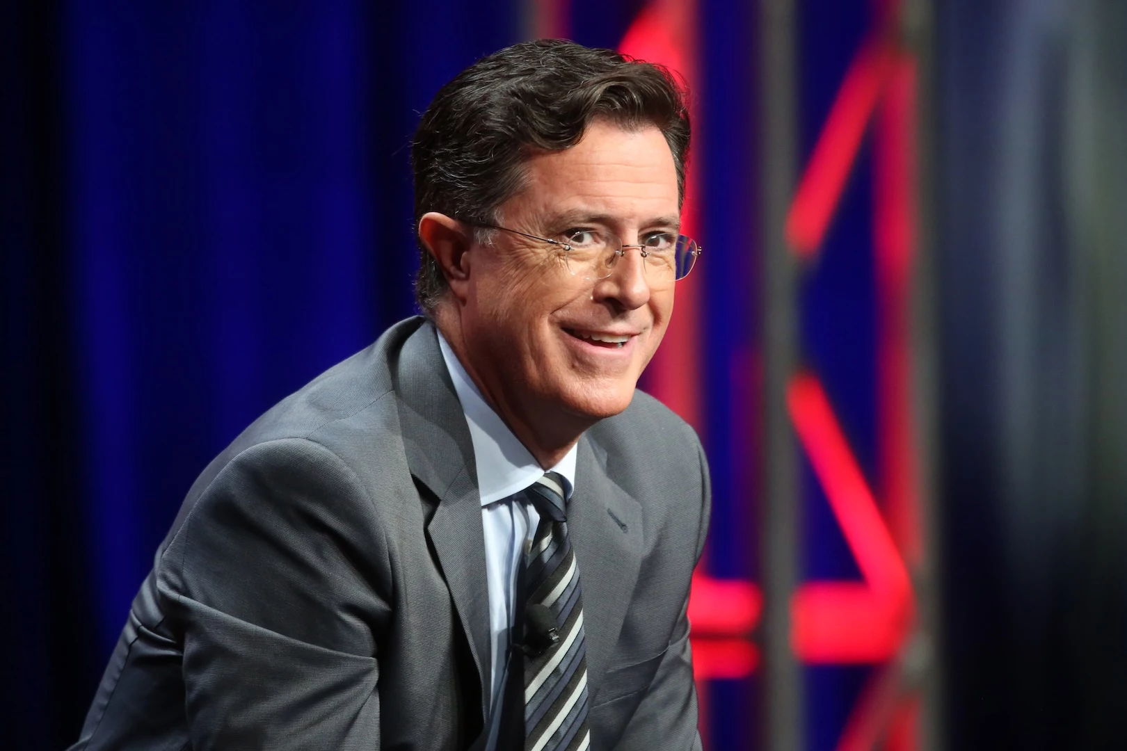 Hombre sonriente con traje y gafas